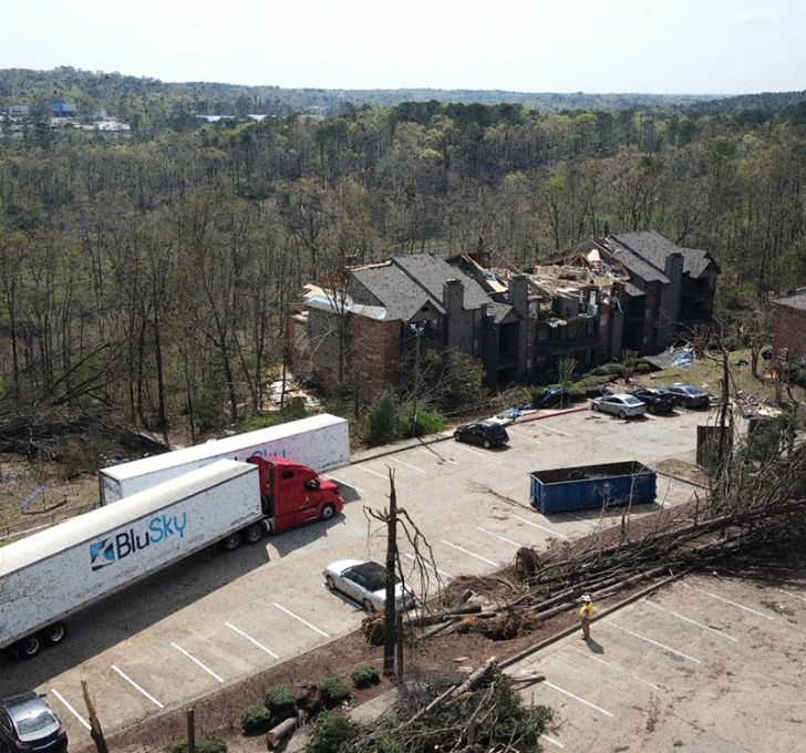 BluSky trucks in front of hurricane damage