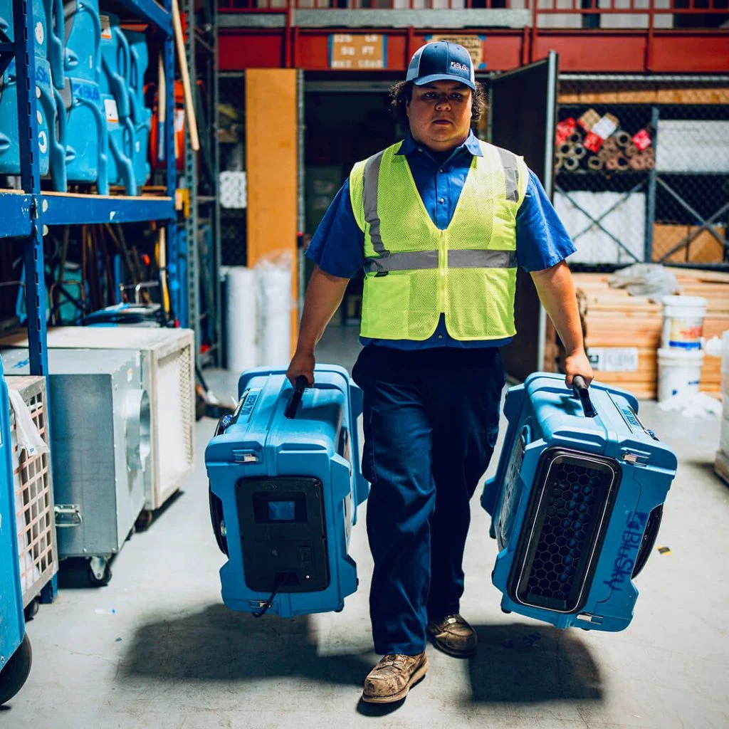 woman carrying water damage equipment