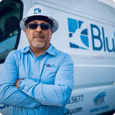 man in BluSky shirt in front of work truck