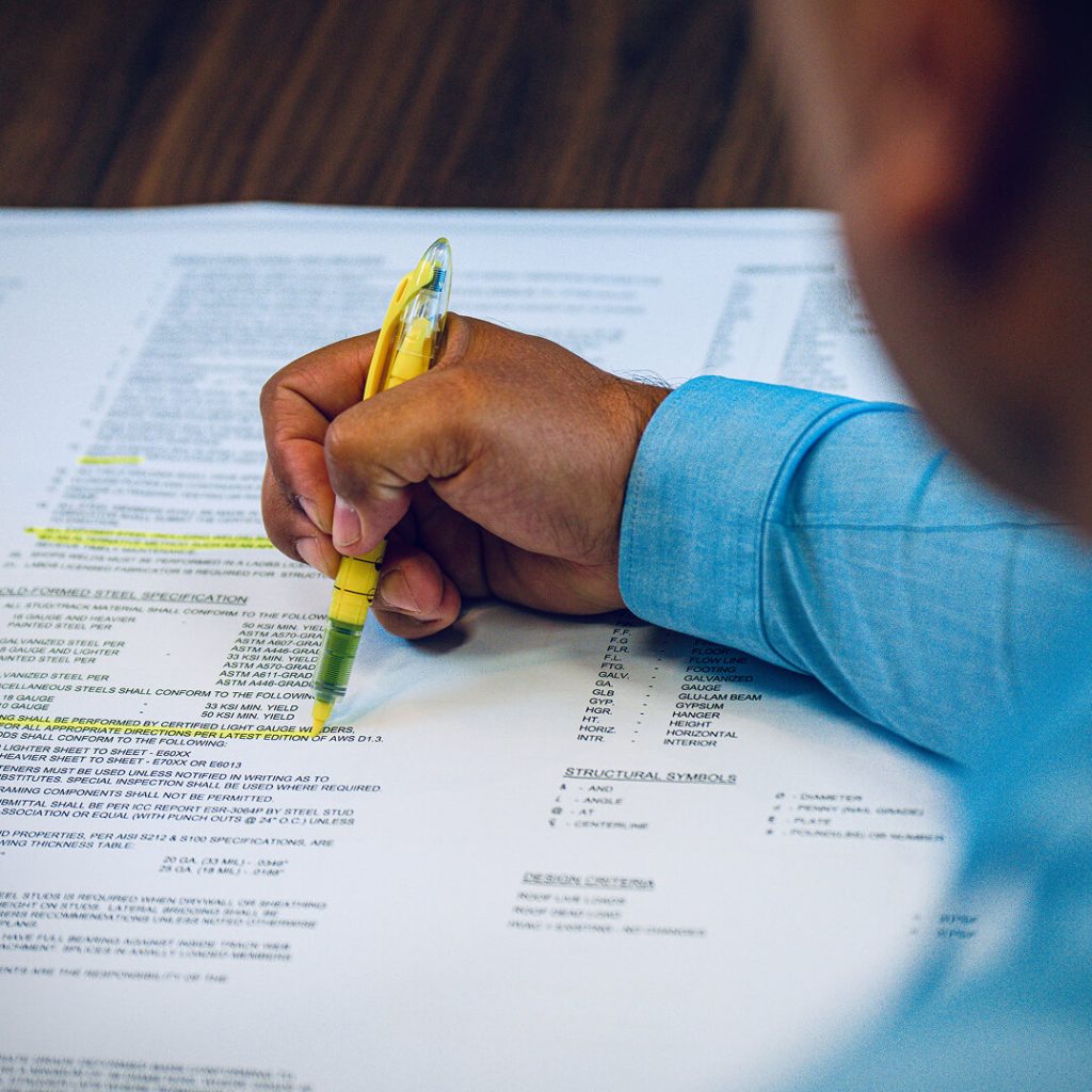 man highlighting sections on paper